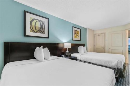 two beds in a hotel room with blue walls at Experience the ultimate beachfront lifestyle at Oceans One 1 Bdr, 16th or17th Fl in Myrtle Beach