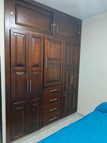 a closet with wooden cabinets in a bedroom at Lindo Apartamento en Socorro in Socorro