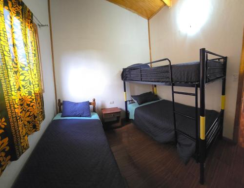 ein Zimmer mit zwei Etagenbetten und einem Fenster in der Unterkunft Mika's House 2 in Hanga Roa