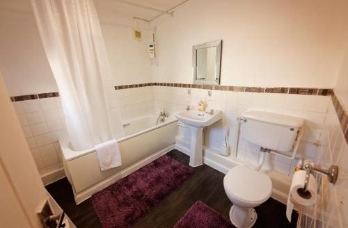 a bathroom with a sink and a toilet and a tub at Silver Bambu Liverpool Hideaway in Liverpool