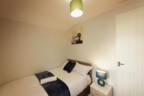 a small bedroom with a bed and a light at Silver Bambu Liverpool Hideaway in Liverpool