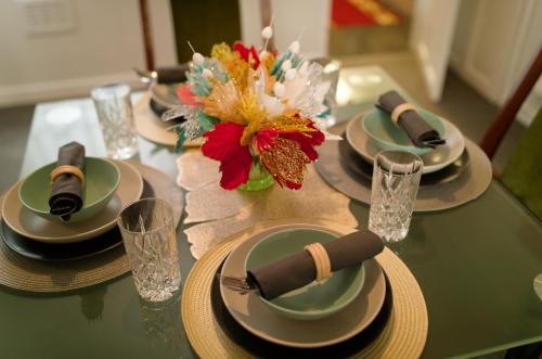 a table with plates and glasses and a vase of flowers at Silver Bambu Liverpool Hideaway in Liverpool