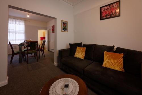 a living room with a black couch and a table at Silver Bambu Liverpool Hideaway in Liverpool
