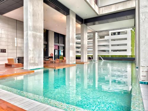 an indoor pool with blue water in a building at Arcoris Mont Kiara in Kuala Lumpur