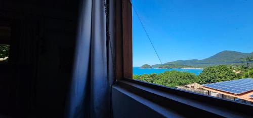 a window with a view of the ocean at Pousada Encontro das Águas in Trindade