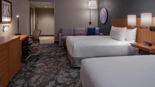 a hotel room with two beds and a desk at Hyatt Place Indianapolis Downtown in Indianapolis
