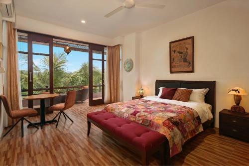 a bedroom with a bed and a table and a desk at The Magic Villa Keramas in Gianyar