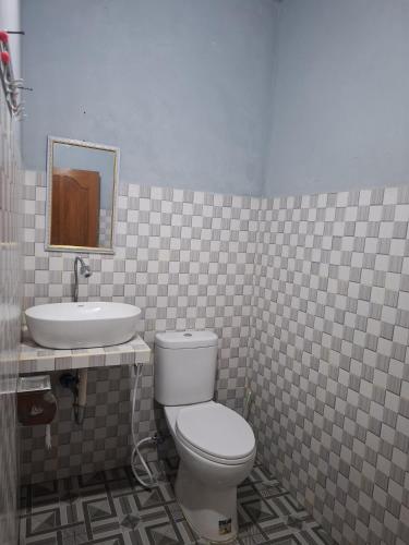 a bathroom with a toilet and a sink at Kelle Homestay in Sidemen