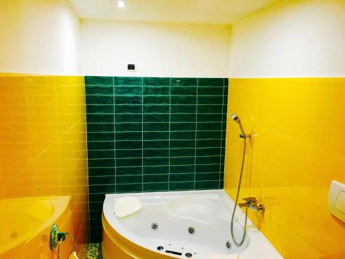 a bathroom with yellow and green walls and a tub at Hotel Villa Felice Relais in Amalfi