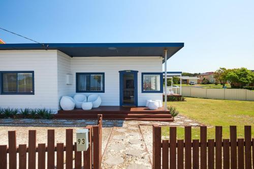 a white house with a fence in front of it at The Shack at Harrington in Harrington