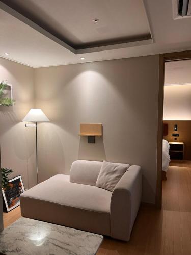a bedroom with a bed and a lamp in a room at Haeundae La Mer in Busan