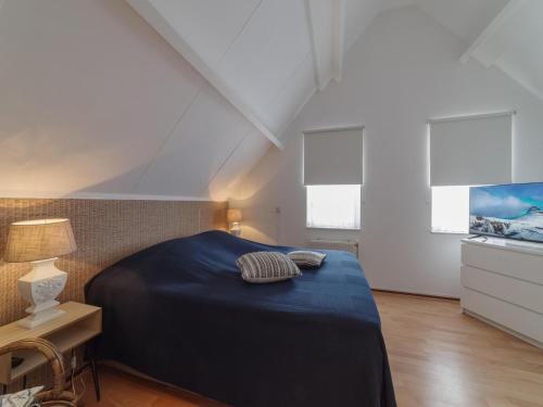a bedroom with a blue bed and two pillows on it at Holiday Home in Zeeland with Spacious Garden in Wemeldinge