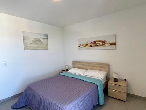 une chambre avec un lit et deux tableaux au mur dans l'établissement Appartement Moderne 2 Chambres avec Terrasse et Vue Imprenable à 50m de la Plage - FR-1-323-234, à Saint-Hilaire-de-Riez