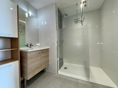 une salle de bain avec une douche, une baignoire et un lavabo dans l'établissement Appartement Moderne 2 Chambres avec Terrasse et Vue Imprenable à 50m de la Plage - FR-1-323-234, à Saint-Hilaire-de-Riez