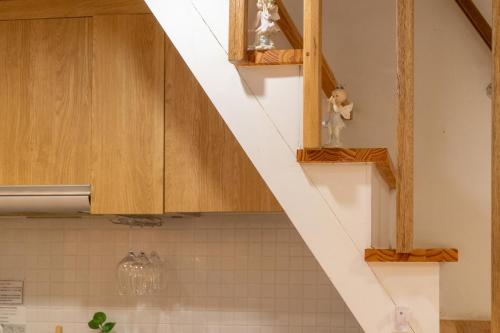 a kitchen with wooden cabinets and a white staircase at Myeongdong Artmonstay in Seoul