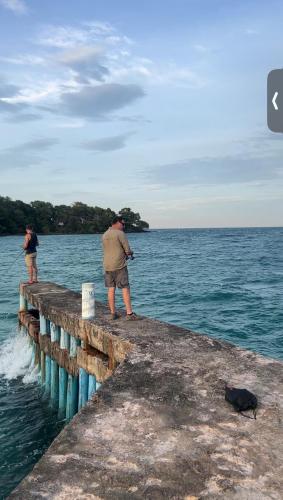 two people standing on a pier in the water at Sunshine Resort Hotel Coconut Beach Koh Rong in Phumĭ Kaôh Rŏng