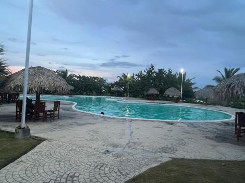 a swimming pool with chairs and umbrellas at Hermoso Apartamento con Jacuzzi Privado in Punta Cana