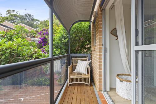 a porch with a chair on a balcony at Bright Coastal Townhouse with BBQ & Courtyard in Avoca Beach