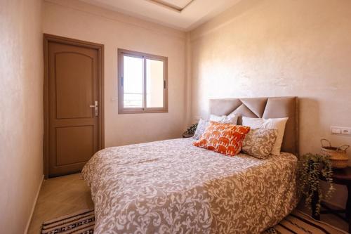 a bedroom with a bed with orange pillows on it at Dar Jo in Tamraght Ouzdar
