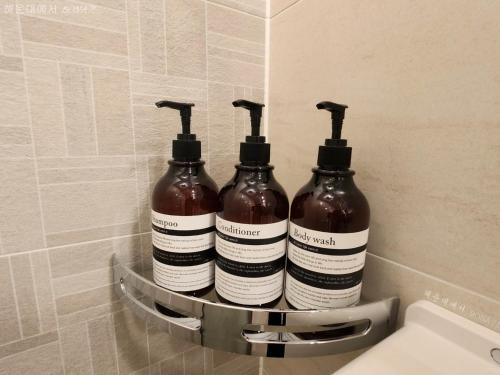 a group of three bottles sitting on a shelf in a bathroom at Haeundae La Mer in Busan
