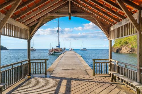 レザンセス・ダルレットにあるBungalow Ixora, bord de merの水上のボートが乗る木製の桟橋