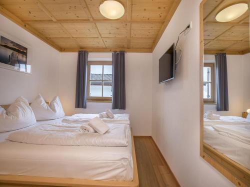 a bedroom with two beds and a mirror at Chalet in Königsleiten near Zillertal Ski Area in Wald im Pinzgau