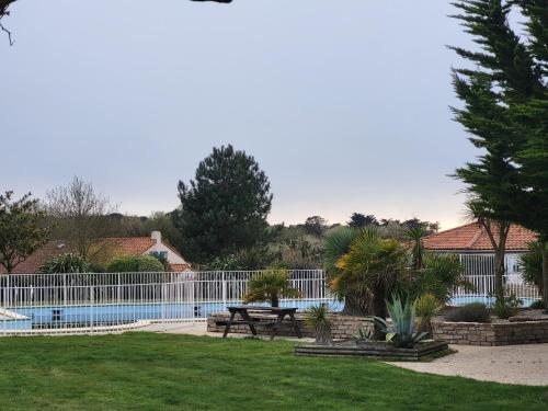 - une piscine avec une clôture et une table de pique-nique dans l'établissement Maison rénovée près de la mer avec 2 piscines, parking et animaux acceptés - FR-1-364-174, à Saint-Michel-Chef-Chef