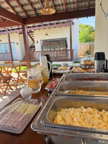 a buffet with trays of food on a table at Encanto da Barra Pousada in Barra Grande