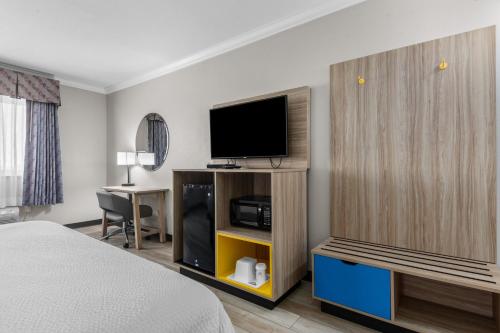 a hotel room with a bed and a flat screen tv at Days Inn by Wyndham Salado in Salado