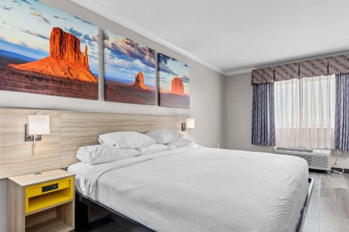 a bedroom with a white bed and a painting on the wall at Days Inn by Wyndham Salado in Salado