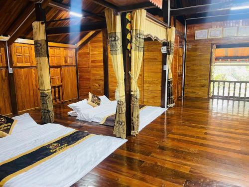 two beds in a room with wooden walls and wooden floors at Hà Giang Homestay in Lan Hung