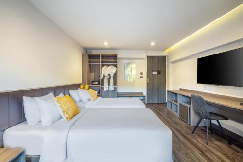 a hotel room with two beds and a flat screen tv at SureStay by Best Western Iconic Ari-Jatujak in Bangkok