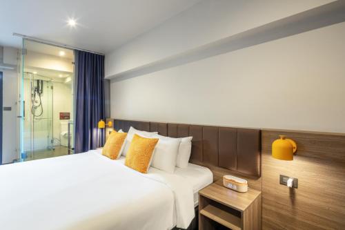 a hotel room with a large bed and a table at SureStay by Best Western Iconic Ari-Jatujak in Bangkok