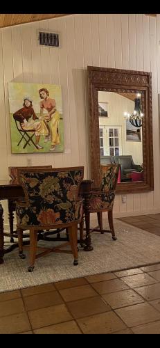 a living room with two chairs and a mirror at Blair House Inn and Spa in Wimberley