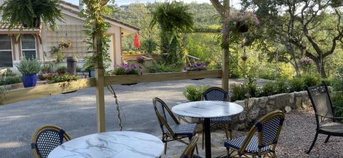 a patio with tables and chairs and a fence at Blair House Inn and Spa in Wimberley