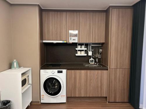 a kitchen with a washing machine and a sink at Haeundae La Mer in Busan
