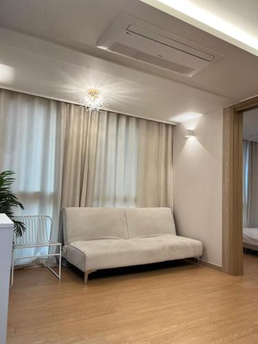 a white couch in a room with a window at Haeundae La Mer in Busan