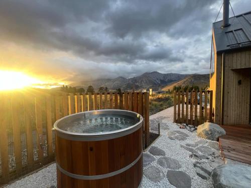 a hot tub on a deck with the sunset at Cedarwood Retreat - Castle Hill Holiday Home in Castle Hill