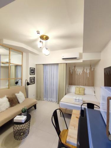 a living room with a bed and a couch at Cozy Studios at Inspiria Condo Davao City beside Abreeza Mall in Davao City