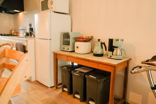 a kitchen with a counter with a refrigerator and trash cans at 青島神社近く 一階貸切 最大六名様まで 暮らすように滞在 in Miyazaki