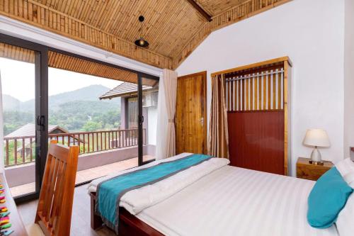 a bedroom with a bed and a balcony at Thang Mây Village - Ba Vì in Ba Vì