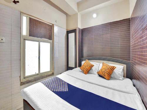 アジメールにあるOYO 85212 Hotel Vaibhavのベッドルーム1室(オレンジと青の枕が付いたベッド1台付)