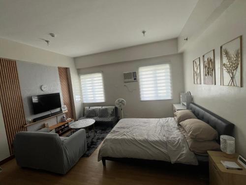 a bedroom with a bed and a couch and a tv at Aras Solace Place in Trece Martires