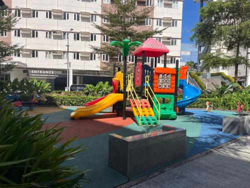 a playground with a slide in a park at Aras Solace Place in Trece Martires