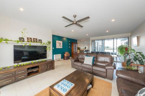 a living room with a large television and leather furniture at Fun in the Sun at Harrington in Harrington