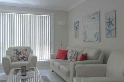 a living room with a couch and a chair at Central Hideaway at Black Head in Hallidays Point