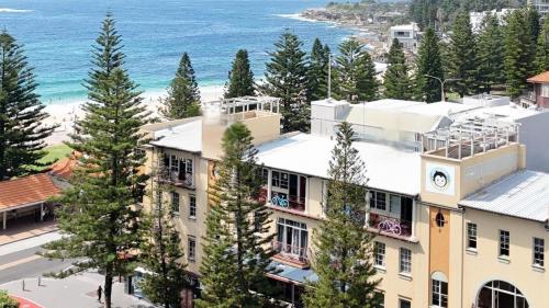 an aerial view of a building with the ocean in the background at Mad Monkey Hostel Coogee Beach in Sydney