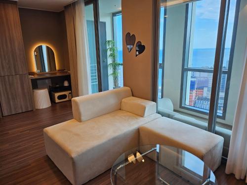 a living room with a couch and a large window at Haeundae La Mer in Busan