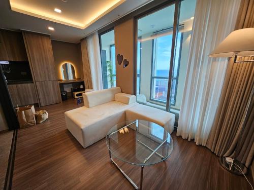 a living room with a white couch and a glass table at Haeundae La Mer in Busan