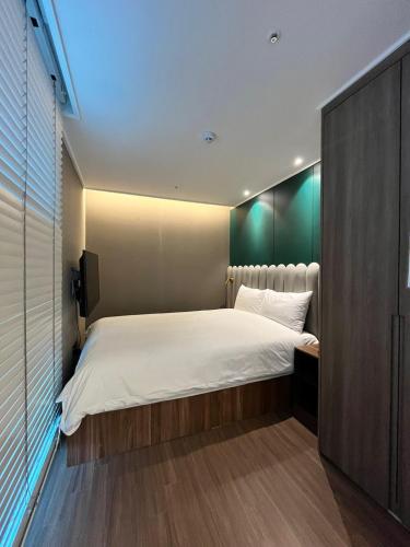 a bedroom with a large white bed and a television at Haeundae La Mer in Busan